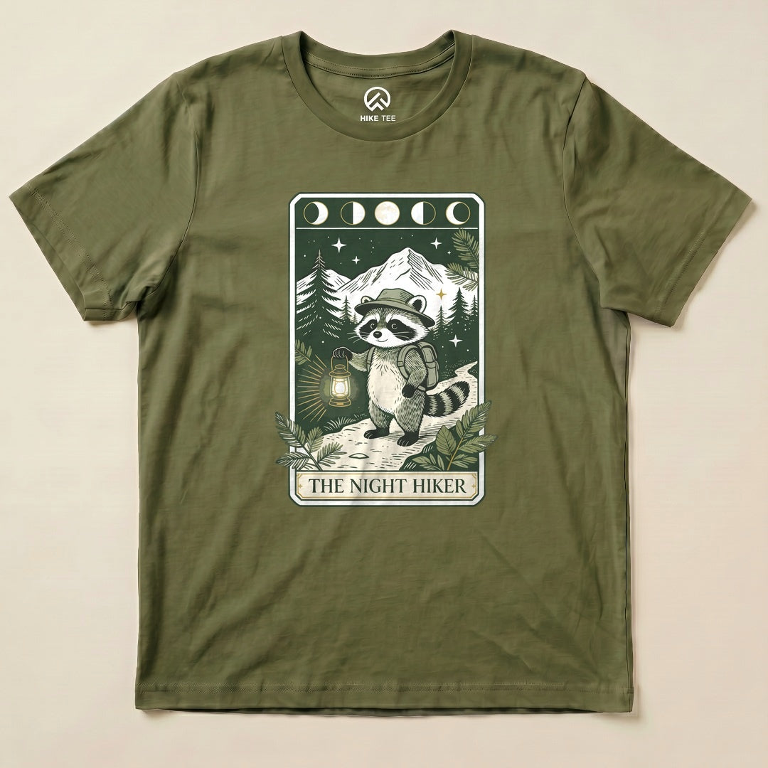 Military Green The Night Hiker Shirt with a raccoon hiker with a lantern on a moonlit tarot card graphic