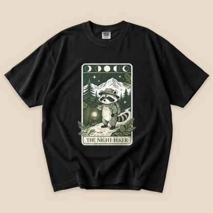 Black The Night Hiker T-Shirt with a raccoon hiker with a lantern on a moonlit tarot card graphic