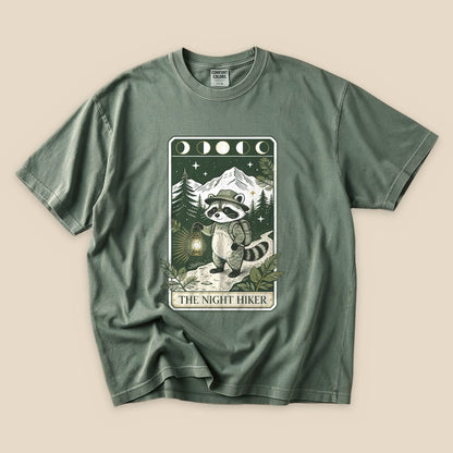 Moss The Night Hiker T-Shirt with a raccoon hiker with a lantern on a moonlit tarot card graphic