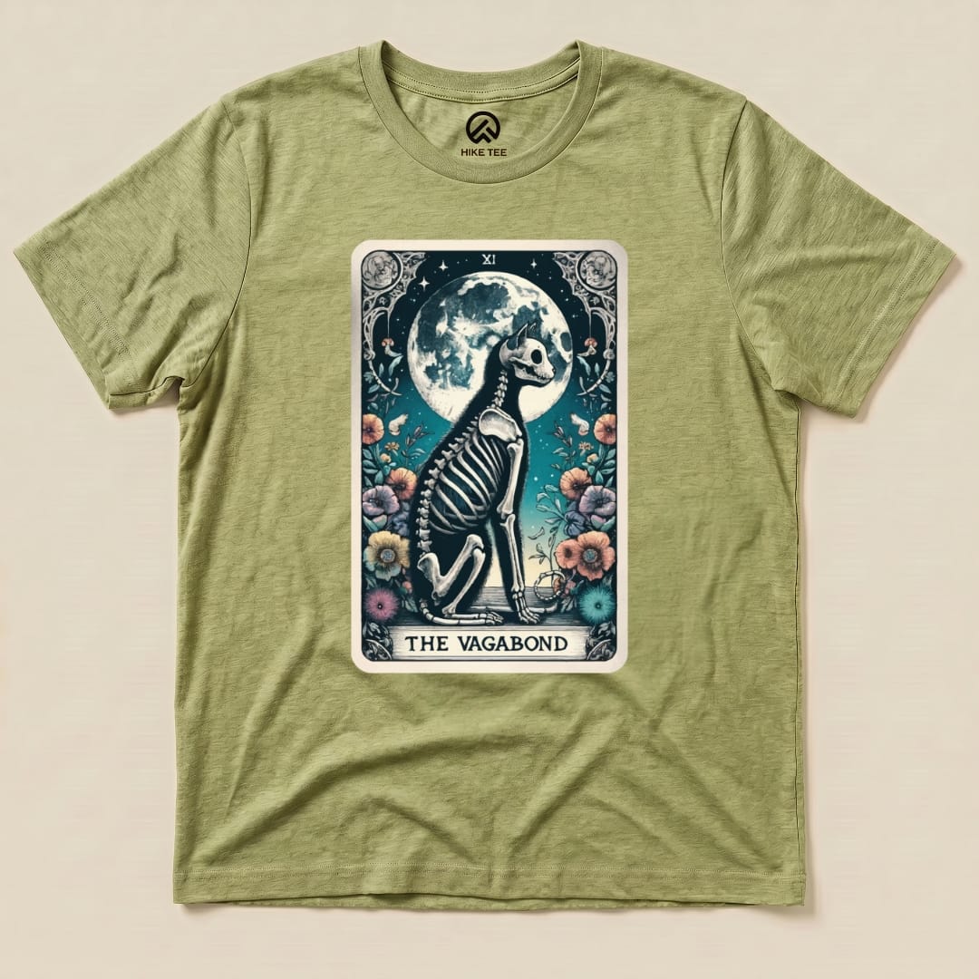 The Vagabond Tarot Card Cat Shirt features a whimsical graphic of a skeleton cat surrounded by flowers and a full moon.