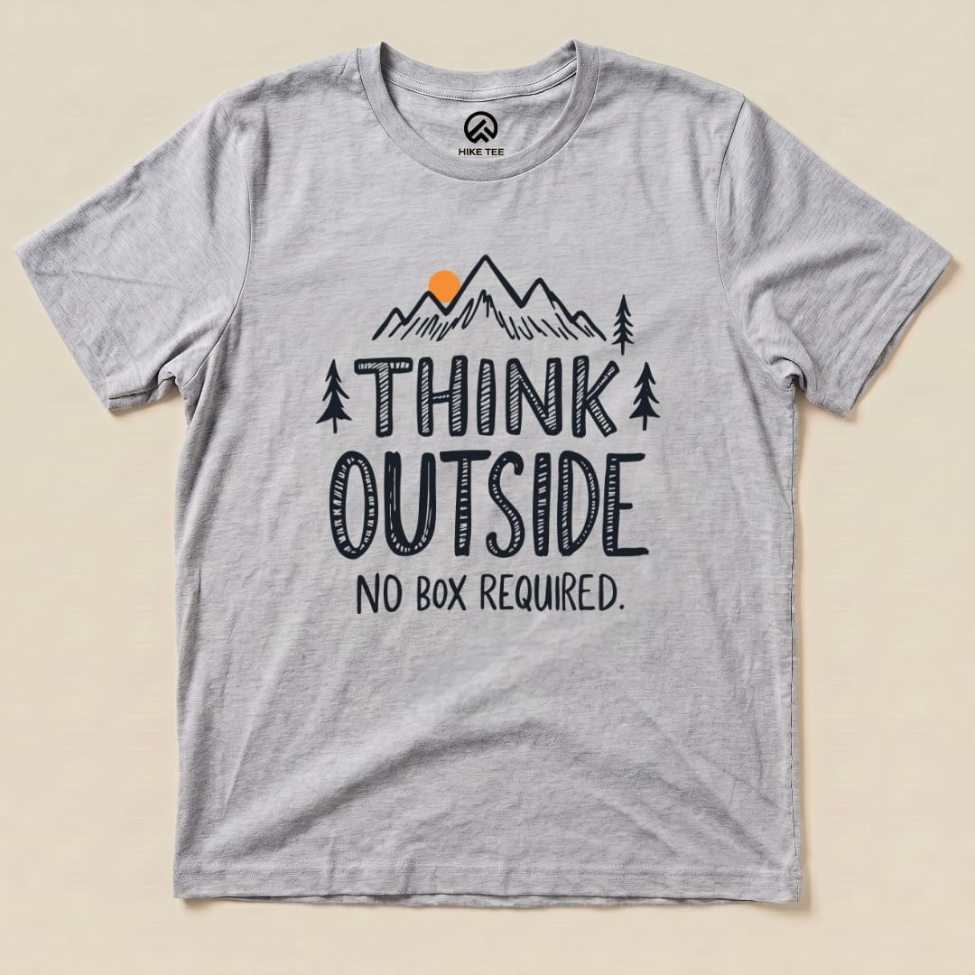 A gray graphic t-shirt features the text "THINK OUTSIDE" above a mountain design, with the slogan "NO BOX REQUIRED." printed below.