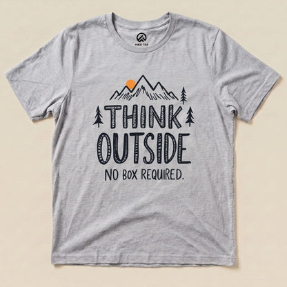 A gray graphic t-shirt features the text "THINK OUTSIDE" above a mountain design, with the slogan "NO BOX REQUIRED." printed below.