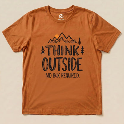A flat graphic t-shirt in a rust color featuring the slogan "THINK OUTSIDE NO BOX REQUIRED" with mountain and tree illustrations.