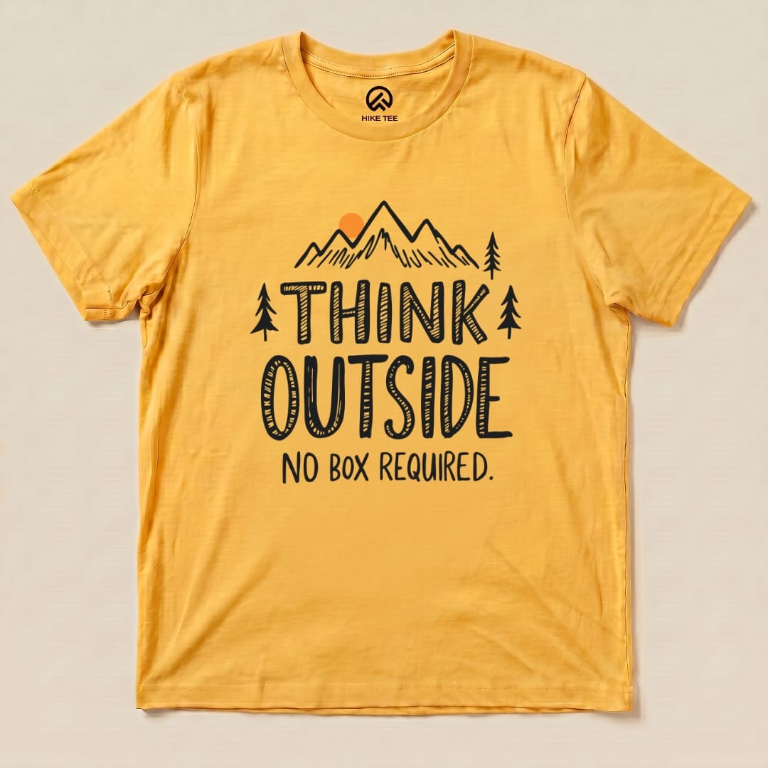A yellow graphic t-shirt displays the slogan "THINK OUTSIDE" above mountains and trees, with "NO BOX REQUIRED" below.