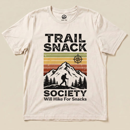 The Trail Snack Society Shirt features a hiker silhouette against a mountain graphic with the phrase "Will Hike For Snacks" below.