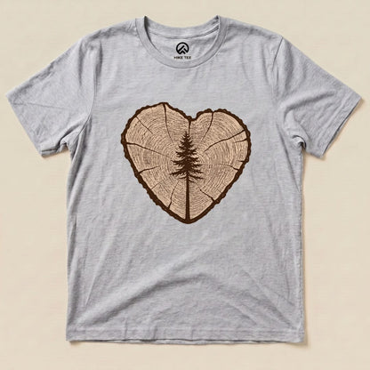 A gray graphic t-shirt featuring a heart-shaped tree ring design with a silhouette of a tree in the center, labeled "Tree Ring Heart Shirt.