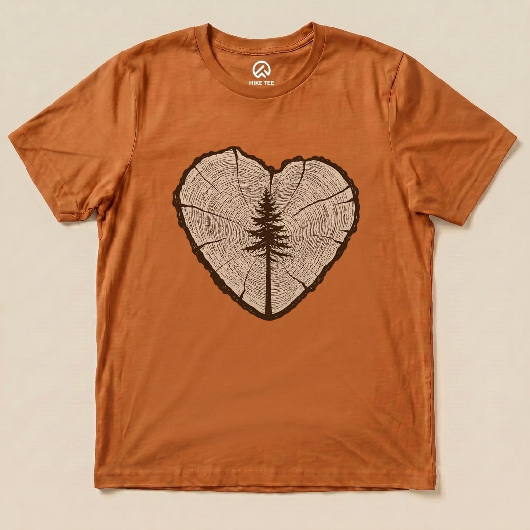 The graphic t-shirt features a heart-shaped tree ring design with a silhouette of a tree in the center, showcasing the "Tree Ring Heart Shirt".
