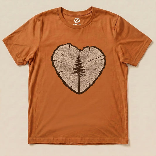 The graphic t-shirt features a heart-shaped tree ring design with a silhouette of a tree in the center, showcasing the "Tree Ring Heart Shirt".