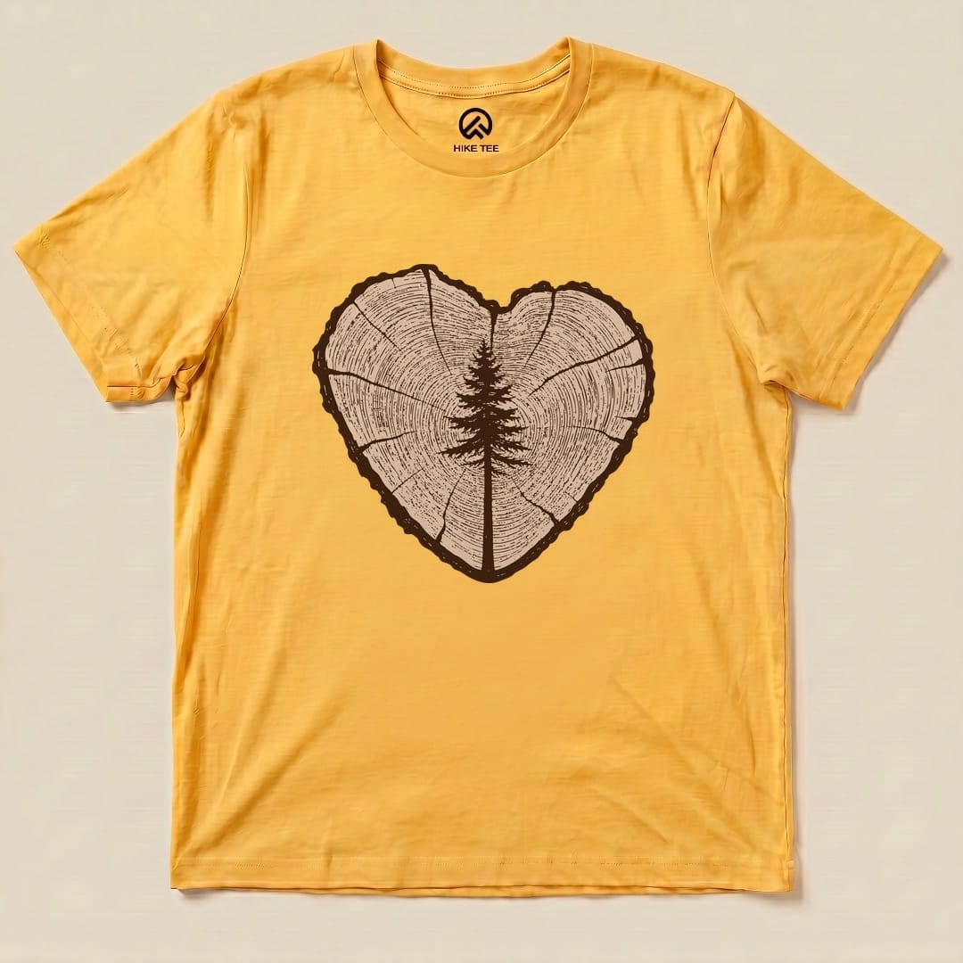 A flat lay of the Tree Ring Heart Shirt, featuring a heart-shaped wood ring graphic with a centered tree design on a yellow background.