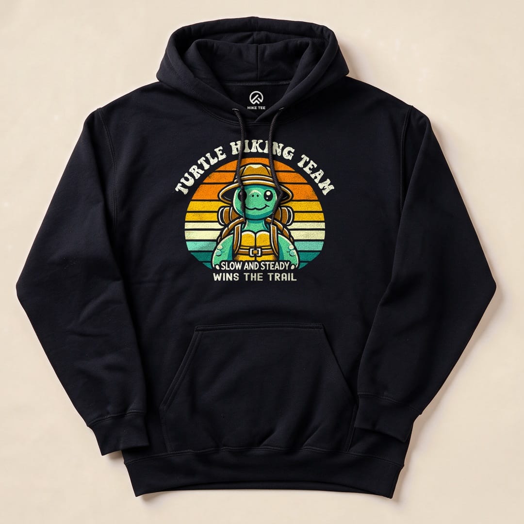 Graphic t-shirt featuring a turtle in a hiking hat and backpack with the text "Turtle Hiking Team - Slow and Steady Wins the Trail.
