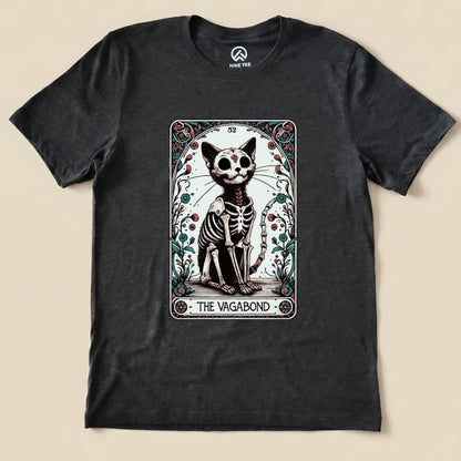 The graphic t-shirt features a whimsical illustration of a skeletal cat in a tarot card design, labeled "The Vagabond.