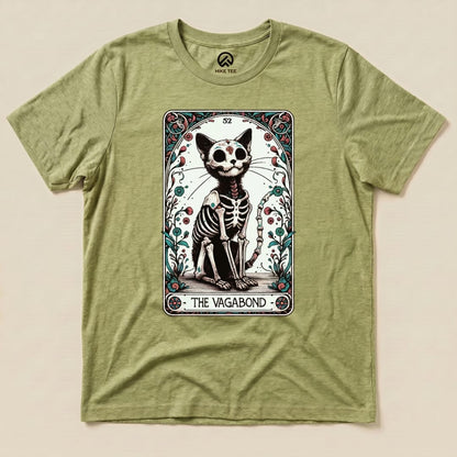 The graphic t-shirt features a whimsical design of a skeletal cat surrounded by floral elements, labeled "THE VAGABOND.