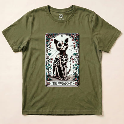 A graphic t-shirt in olive green featuring a whimsical skeleton cat design, titled "The Vagabond," surrounded by decorative elements.