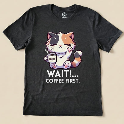 A black graphic t-shirt features a cute cartoon cat holding a coffee cup with the text "WAIT!... COFFEE FIRST.