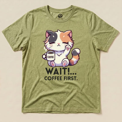 Graphic t-shirt featuring a cute cat holding a coffee cup with the text "WAIT!... COFFEE FIRST." on an olive green background.