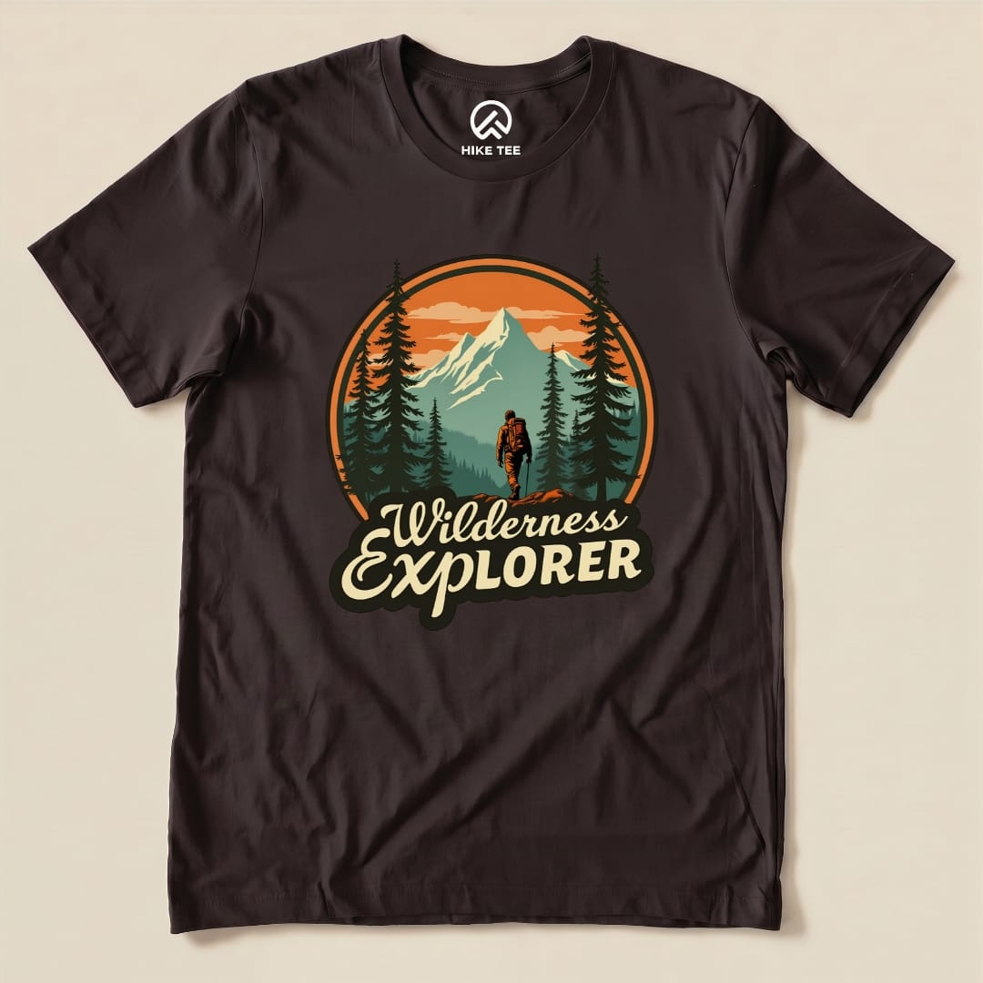 A graphic t-shirt featuring the "Wilderness Explorer Shirt" design with a hiker, mountains, and trees in vibrant colors.