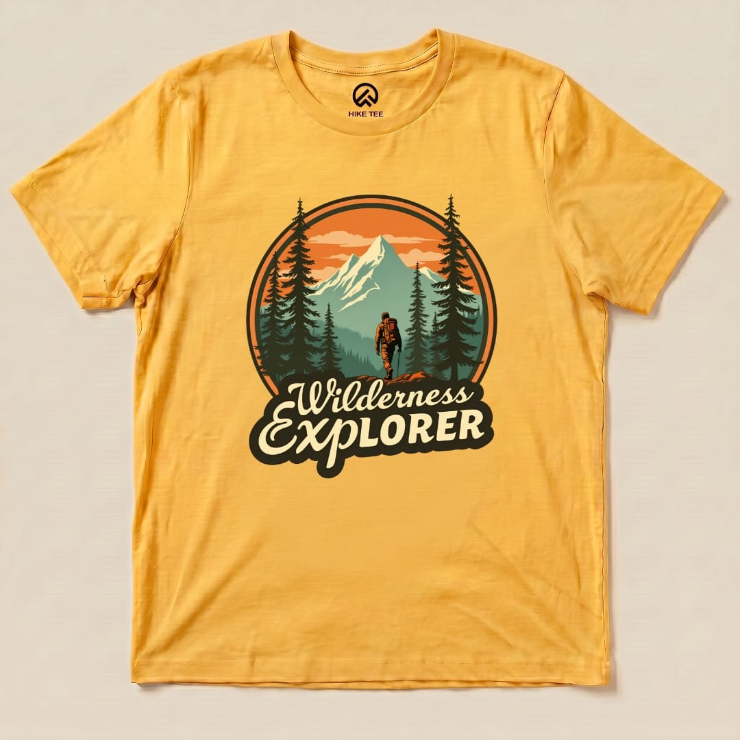 The graphic t-shirt features a "Wilderness Explorer Shirt" design with a hiker walking among trees and mountains in a vibrant sunset.