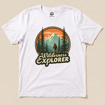 A flat white graphic t-shirt featuring the "Wilderness Explorer Shirt" design with a mountain scene and the text "Wilderness Explorer".