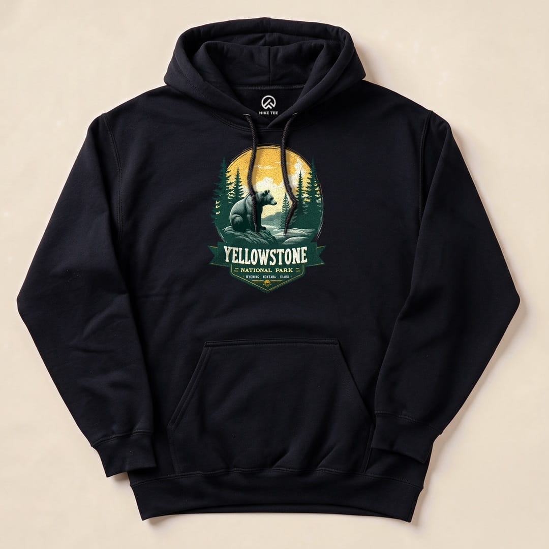 A black hoodie featuring a graphic of a grizzly bear with trees and a sunset, showcasing the "Yellowstone Grizzly Bear Hoodie" design.