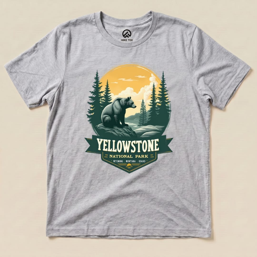 A graphic t-shirt featuring a Yellowstone Grizzly Bear Shirt design, showcasing a bear surrounded by trees and mountains.