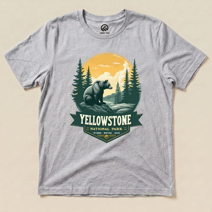 A graphic t-shirt featuring a Yellowstone Grizzly Bear Shirt design, showcasing a bear surrounded by trees and mountains.