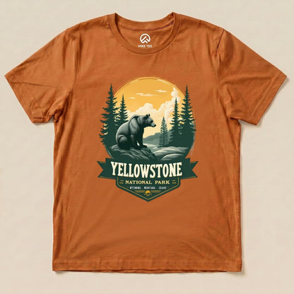 Graphic t-shirt featuring a grizzly bear and forest scene with the words "Yellowstone National Park" in a warm orange color.