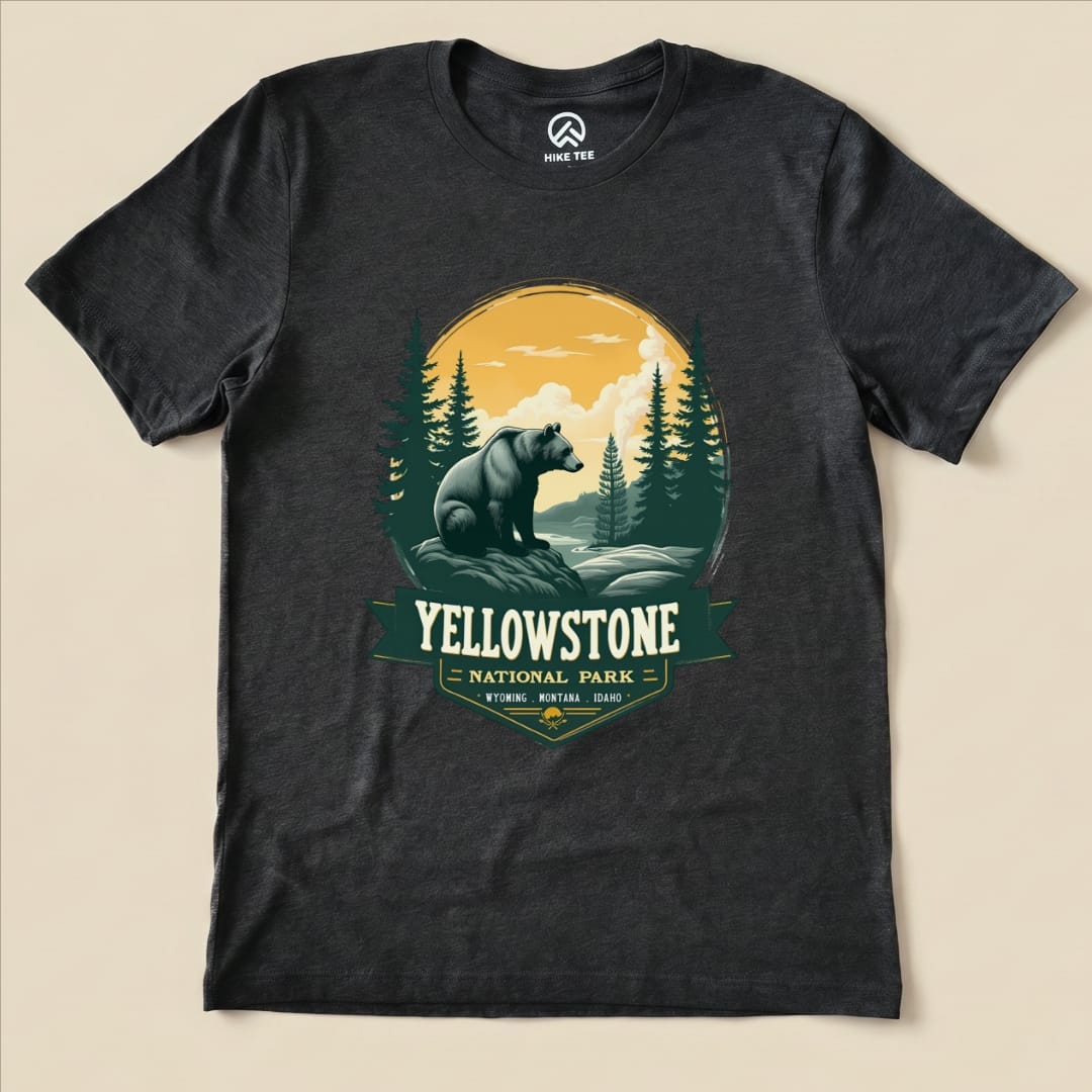 A graphic t-shirt featuring a Yellowstone Grizzly Bear design with mountains and trees, highlighted by the words "Yellowstone National Park.