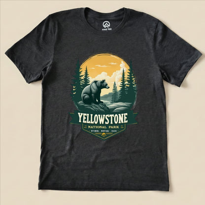 A graphic t-shirt featuring a Yellowstone Grizzly Bear design with mountains and trees, highlighted by the words "Yellowstone National Park.