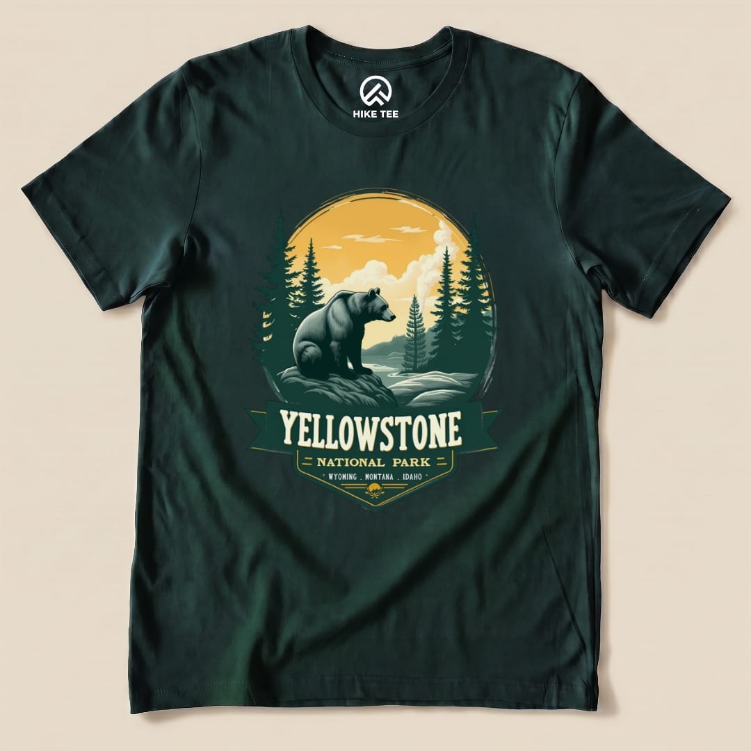 A graphic t-shirt featuring a Yellowstone Grizzly Bear Shirt design with a bear, trees, and a scenic backdrop in earthy colors.