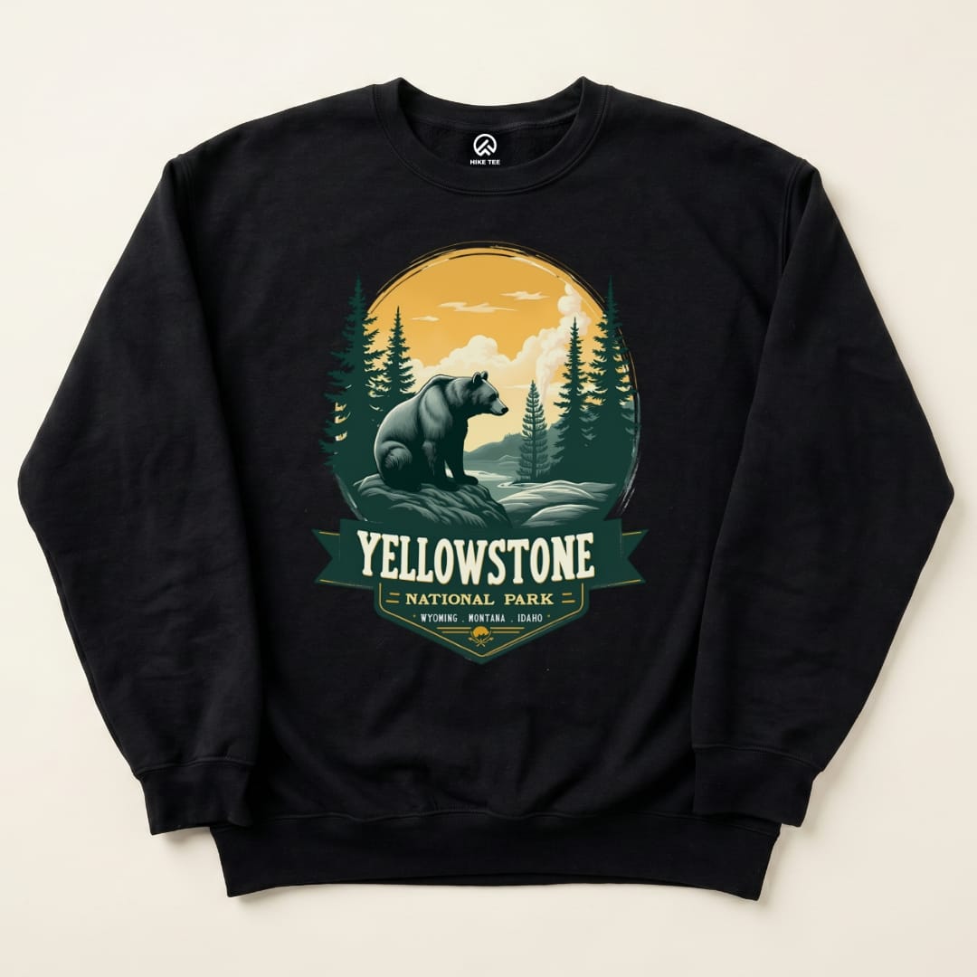 The image shows a black "Yellowstone Grizzly Bear Sweatshirt" featuring a graphic of a bear surrounded by pine trees and mountains.