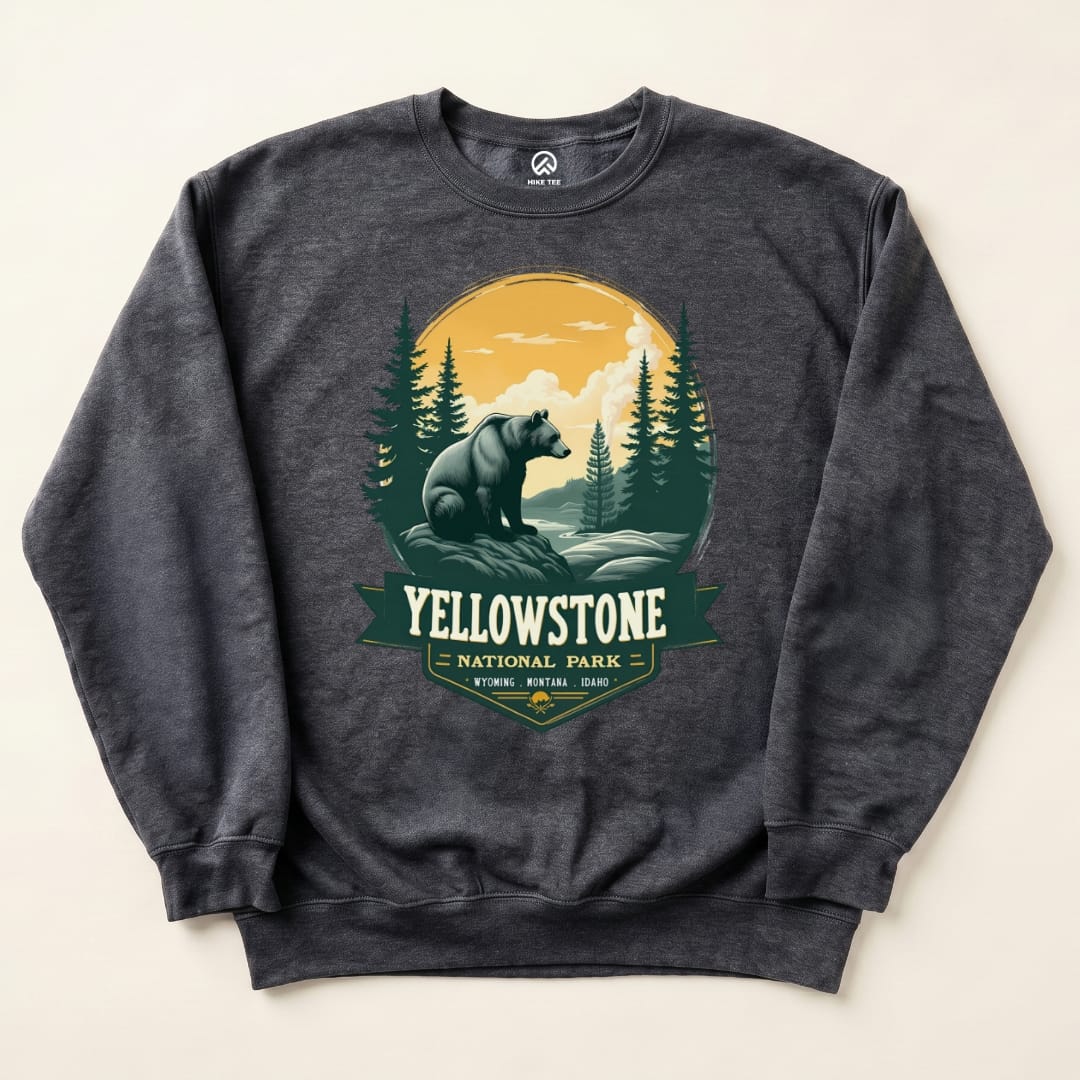 A graphic sweatshirt featuring a Yellowstone Grizzly Bear design with mountains and trees in a vintage style.