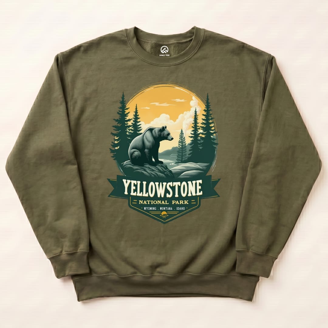 A graphic sweatshirt featuring a Yellowstone Grizzly Bear design with a scenic background of mountains and trees.