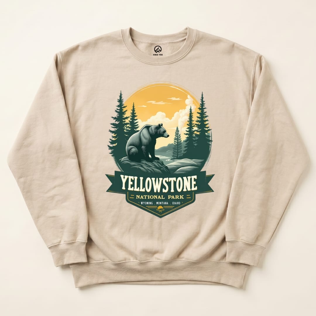 A beige Yellowstone Grizzly Bear Sweatshirt featuring a graphic of a bear against a scenic backdrop with trees and mountains.