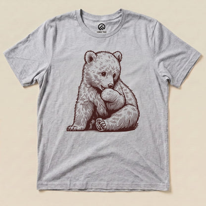 A graphic t-shirt featuring a cute bear illustration, labeled as the "Youth Bear Shirt," set against a light background.