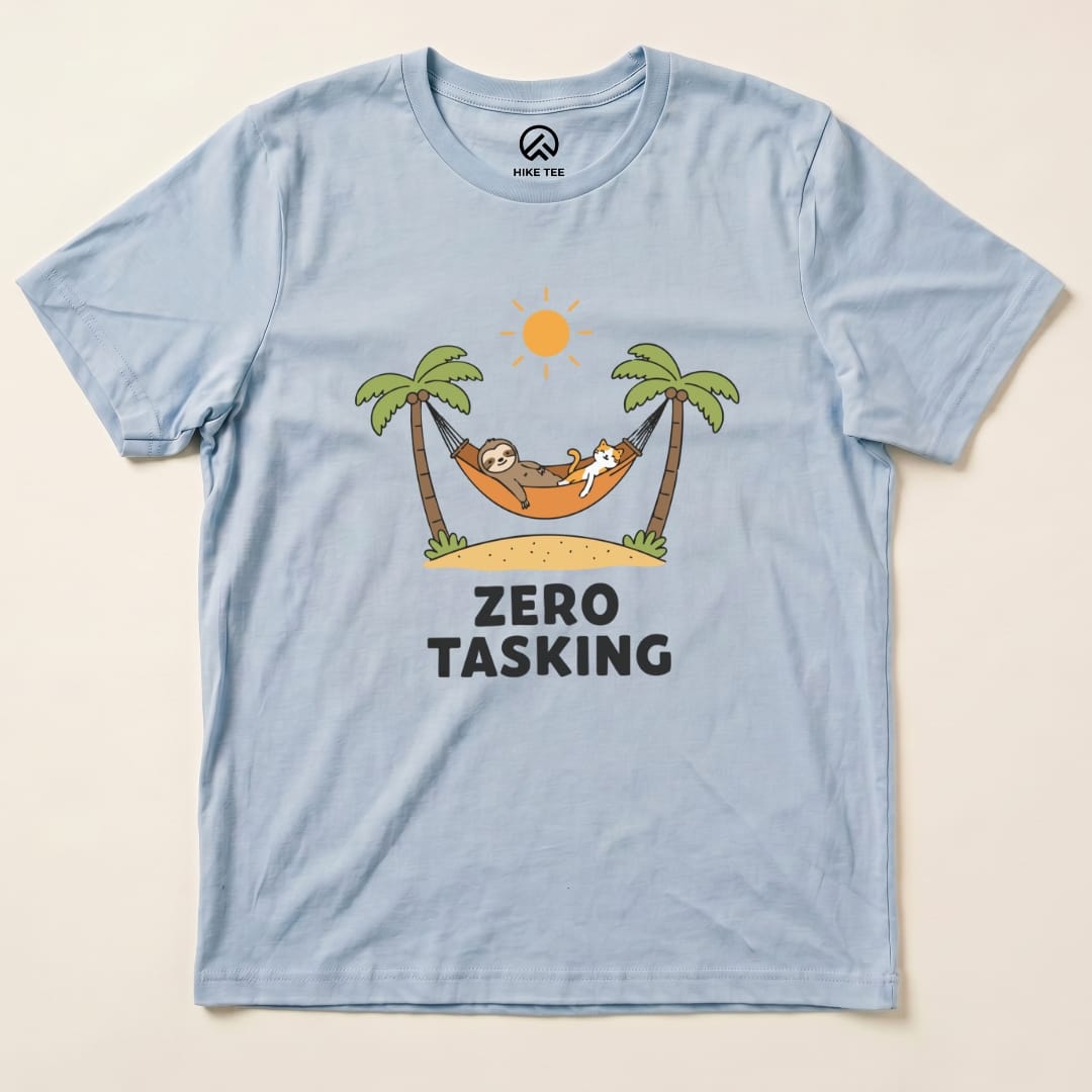 The light blue graphic t-shirt features a sloth and a cat relaxing in a hammock with the text "ZERO TASKING" below them.
