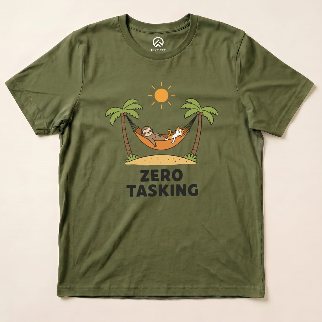 The graphic t-shirt features a sloth and a cat lounging in a hammock under palm trees with the text "ZERO TASKING".