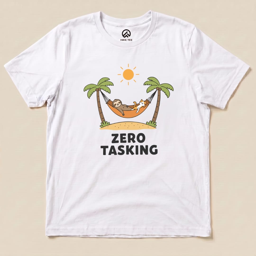 A graphic t-shirt featuring a sloth and a cat lounging in a hammock under palm trees with the slogan "ZERO TASKING.