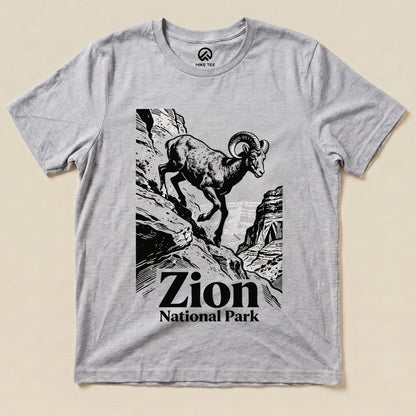 A graphic t-shirt featuring a ram climbing rocky terrain, with "Zion National Park" text below the design.