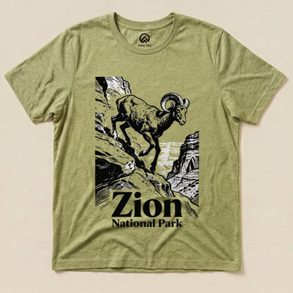 Graphic t-shirt featuring a mountain goat climbing rocky terrain with "Zion National Park" text below the design.
